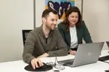 verzekeringsadviseurs Stein en Patricia kijken samen op een laptop